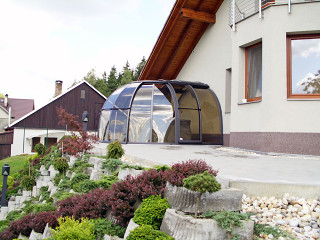 Zastřešení vířivé vany OASIS™ přiléhá k domu